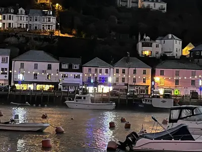 a harbor at night with boats in the water at Quayview in Looe