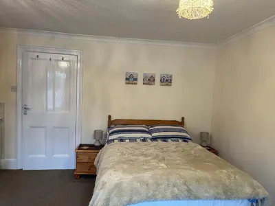 a bedroom with a bed and a chandelier at Quayview in Looe
