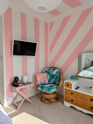 a bedroom with a pink and white striped wall at Treheveras Guest House in Newquay