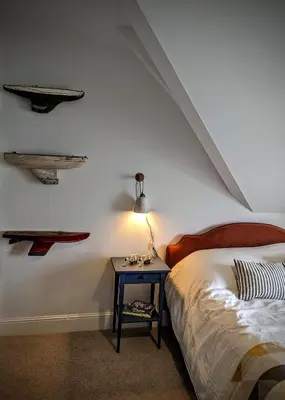 a bedroom with a bed and a table with a lamp at Treheveras Guest House in Newquay