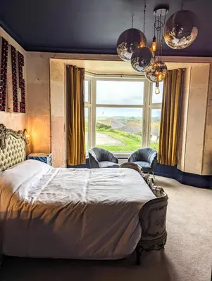 a bedroom with a large bed and a large window at Treheveras Guest House in Newquay