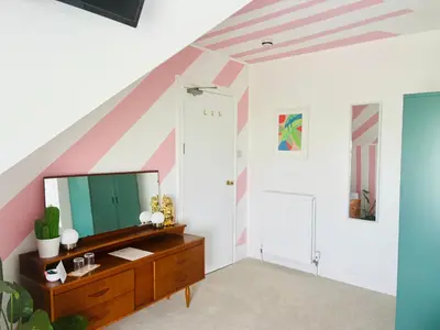 a room with a dresser and a striped wall at Treheveras Guest House in Newquay