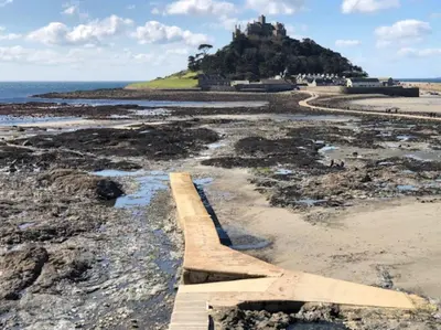 a plane on the beach with a castle in the background at Carbis Bay luxury ground floor flat close to beach in Carbis Bay