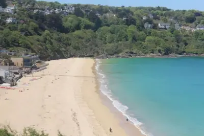 a view of a beach with people in the water at Carbis Bay luxury ground floor flat close to beach in Carbis Bay