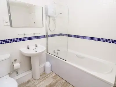 a bathroom with a sink and a shower and a toilet at The Mariners in Helston
