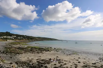 a group of people sitting on a beach at The Mariners in Helston