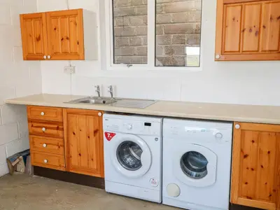 a kitchen with a washing machine and a sink at The Mariners in Helston