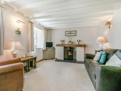 a living room with a couch and a fireplace at Myrtle Cottage in Saint Just in Roseland