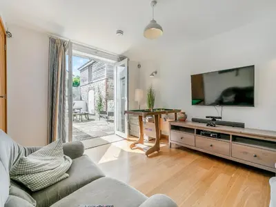 a living room with a couch and a tv at Myrtle Cottage in Saint Just in Roseland