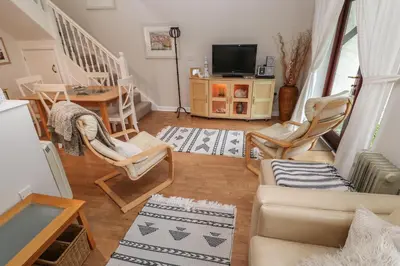 a living room with a couch and chairs and a tv at Albert's Den in Falmouth