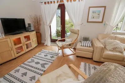 a living room with a couch and a tv at Albert's Den in Falmouth