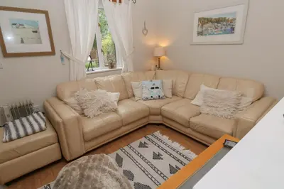 a living room with a couch and a table at Albert's Den in Falmouth