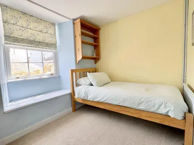 a small bedroom with a bed and a window at Coswarth Cottage in Padstow