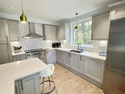 a kitchen with white cabinets and a white counter top at Coswarth Cottage in Padstow