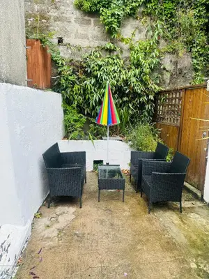 a colorful umbrella sitting on a table with chairs at Alexander cottage in Penryn