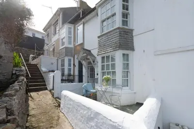 a white house with a white fence in front of it at Cottage By The Sea, Wi-Fi, Pets Accepted in St Ives