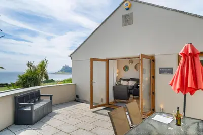 a patio with a view of the ocean from a house at Rosemerryn in Marazion