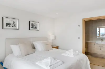 a white bed with two towels on top of it at Rosemerryn in Marazion