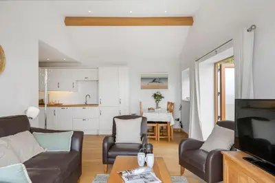 a living room with a couch and a tv at Rosemerryn in Marazion