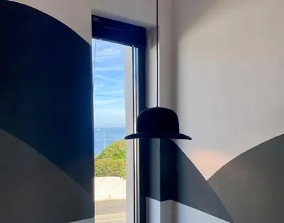 a black pendant light hanging in front of a window at Mevagissey Boutique Flatlet with sea and countryside views in Mevagissey