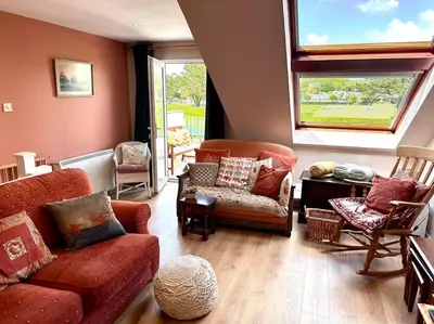 a living room with a couch and chairs and a window at Riverside home by Camel Trail in Cornwall in Wadebridge