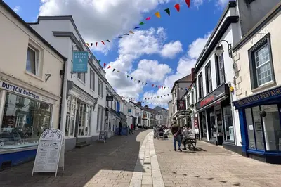 a city street with people walking down a street at Riverside home by Camel Trail in Cornwall in Wadebridge