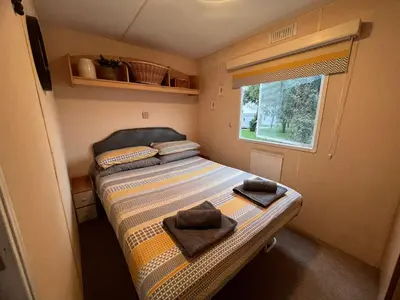 a small bedroom with a bed with towels on it at Seven Bays Holiday Home in Padstow