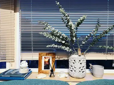 a vase with flowers in it sitting on a table at Seven Bays Holiday Home in Padstow