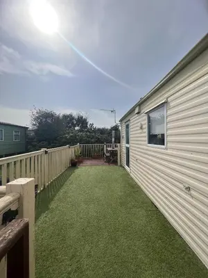 a yard next to a house with a fence at Seven Bays Holiday Home in Padstow