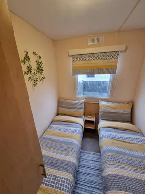 a small room with two beds and a window at Seven Bays Holiday Home in Padstow