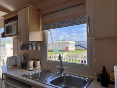 a kitchen counter with a sink and a window at Seven Bays Holiday Home in Padstow
