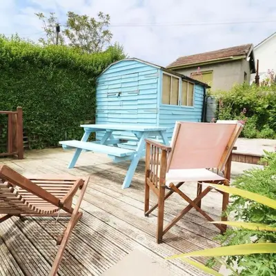 a blue picnic table and two chairs and a house at Mellow Cottage just a short walk to the beach in Perranporth
