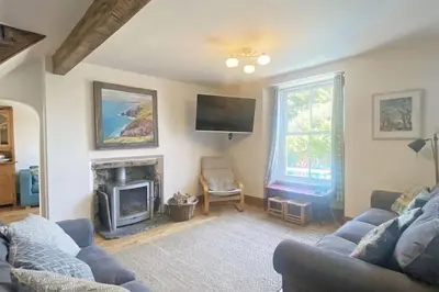 a living room with a couch and a fireplace at Mellow Cottage just a short walk to the beach in Perranporth