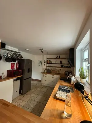 a kitchen with a wooden table in a room at Mellow Cottage just a short walk to the beach in Perranporth