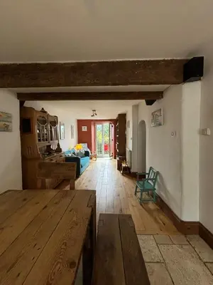 a large living room with a table and a bed at Mellow Cottage just a short walk to the beach in Perranporth