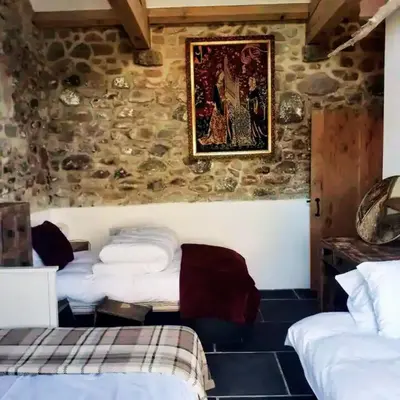 a room with two beds and a painting on the wall at The Stables in St Ives in St Ives