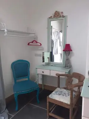 a bathroom with a blue chair and a mirror at The Stables in St Ives in St Ives