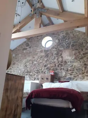 a bedroom with a stone wall with a bed and a window at The Stables in St Ives in St Ives