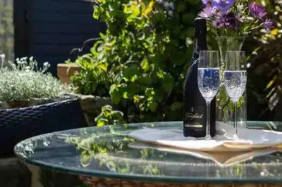 a bottle of wine and two glasses on a table at The Stables in St Ives in St Ives