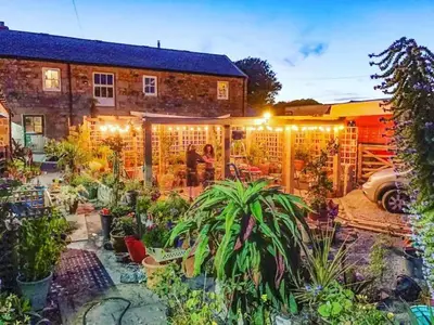 a garden in front of a house with lights at The Stables in St Ives in St Ives