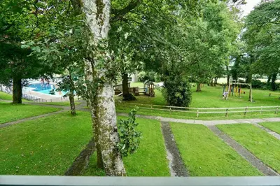 a view of a park with a playground and trees at Special 2 Bedroom Home in White Cross in Saint Columb Major