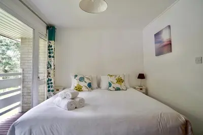 a bedroom with a white bed with towels on it at Special 2 Bedroom Home in White Cross in Saint Columb Major