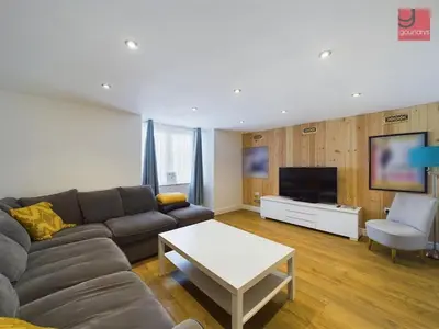 a living room with a couch and a tv at TruroFlat in Truro