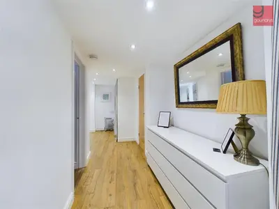 a white dresser with a mirror and a lamp on it at TruroFlat in Truro