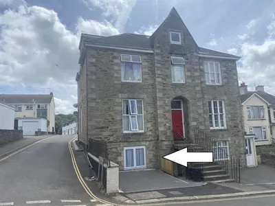 a brick house with a red door on a street at TruroFlat in Truro