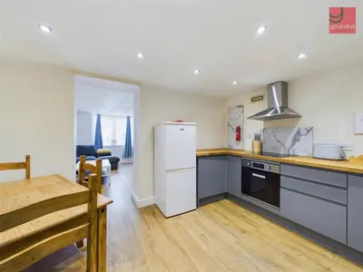 a kitchen with a white refrigerator and a table at TruroFlat in Truro