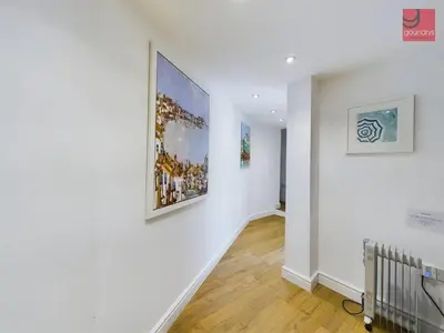a hallway with two paintings on the wall at TruroFlat in Truro