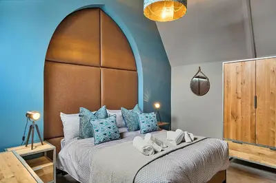 a bedroom with a large bed with blue walls at Finest Retreats - Towan House in Newquay