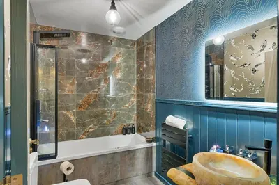 a bathroom with a tub and a sink and a mirror at Finest Retreats - Towan House in Newquay