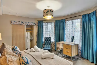 a bedroom with two beds and a desk and a chair at Finest Retreats - Towan House in Newquay